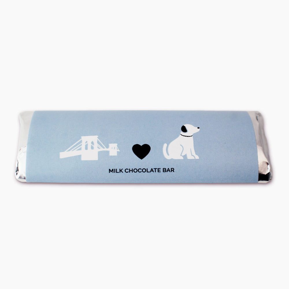 Custom milk chocolate bar with purple wrapper. A bridge, a heart, and a dog are on the wrapper in black and white. Milk Chocolate is written on the bottom of the bar in black text.