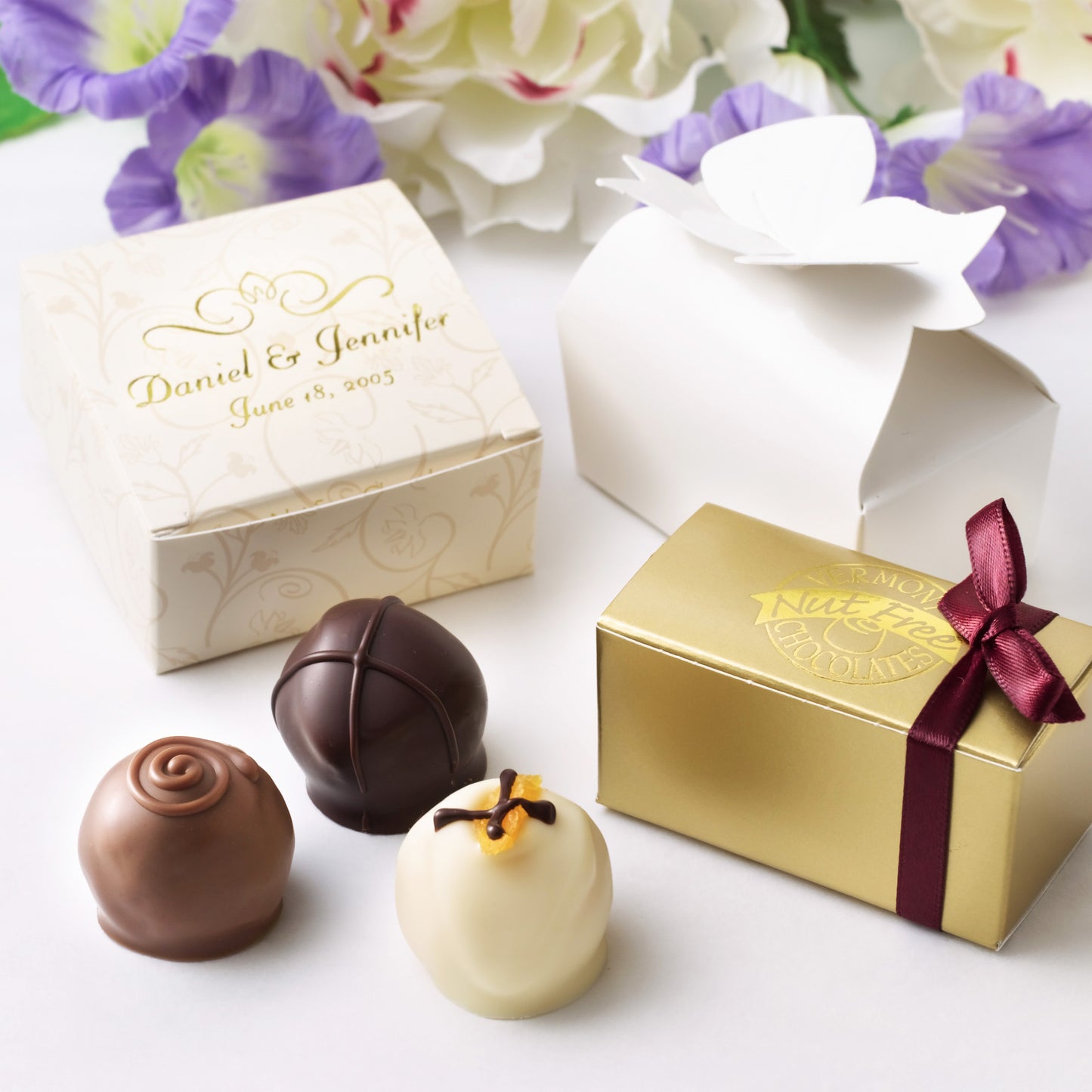 Truffles in front of small cardboard boxes, some of which are engraved with names